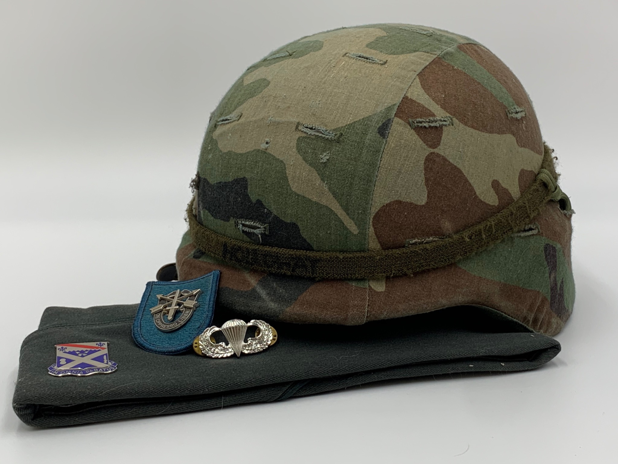 U.S. Army helmet, green beret, Special Forces crest, and parachutist badge